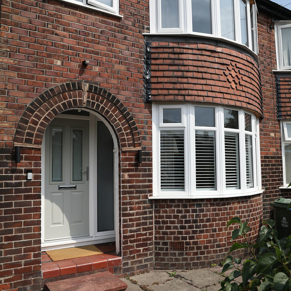 Exterior of a 1930s semi detached house with a green door