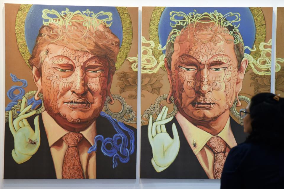 A visitor looks at a painting representing US President Donald Trump (L) and Russian President Vladimir Putin made by Nepalese artist Sunil Sidgel at the India Art Fair in New Delhi on January 2, 2017.&nbsp;