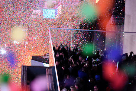 Revelers celebrate as confetti falls in Times Square just after midnight during New Year celebrations in Manhattan, New York, U.S., January 1, 2018. REUTERS/Darren Ornitz