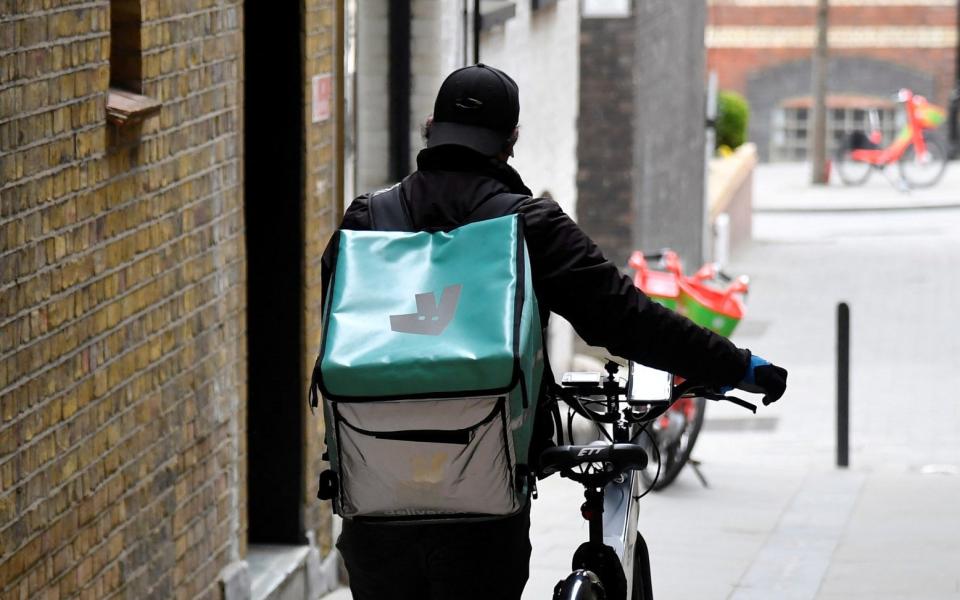 A Deliveroo delivery rider pushes a bicycle in London, Britain - TOBY MELVILLE / REUTERS