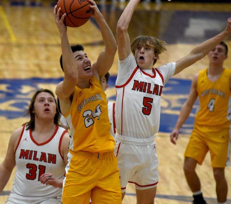 Kirby Carsten of Ida goes to the hoop pressured by Jackson Raasch (5) behind Logan Aeschbacker of Milan in the Division 2 District semifinals at Dundee High School Thursday.