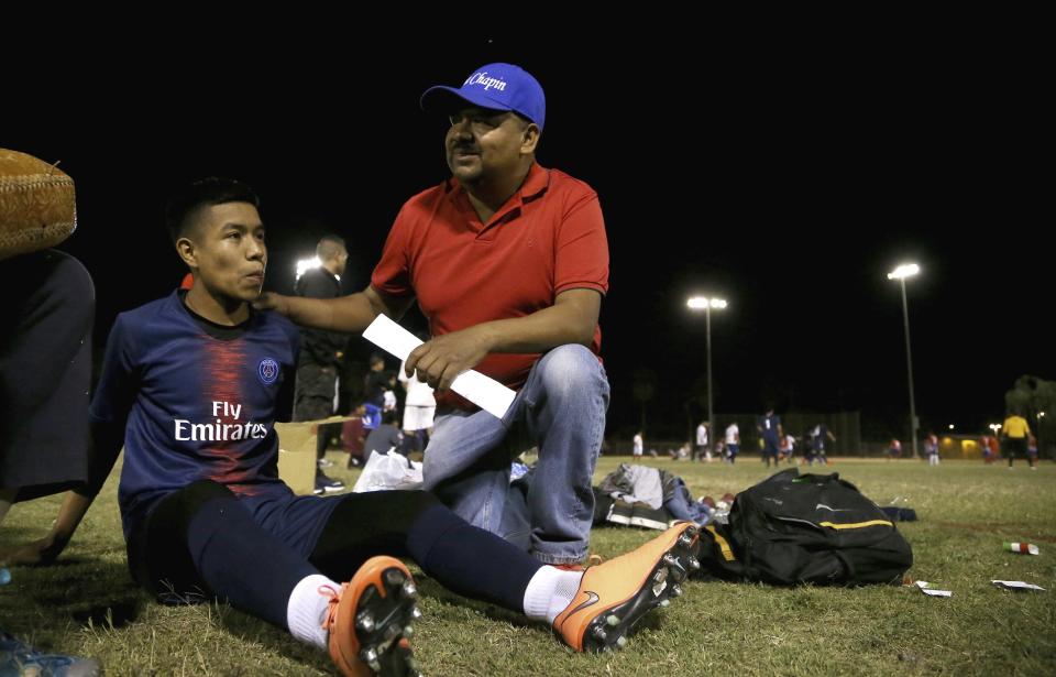 Antonio Velasquez, right, a pastor and director of the Maya Chapin soccer league, talks with player William Sebastian, 16, left, during a break in a soccer league game Wednesday, April 17, 2019, in Phoenix. (AP Photo/Ross D. Franklin)