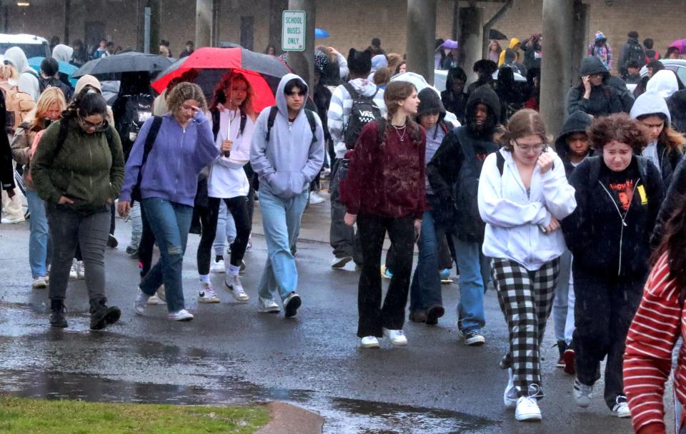 Riverdale students walk in the rain as they hurry to change classes to and from the annex at Riverdale High School on Wednesday, March 22, 2023.