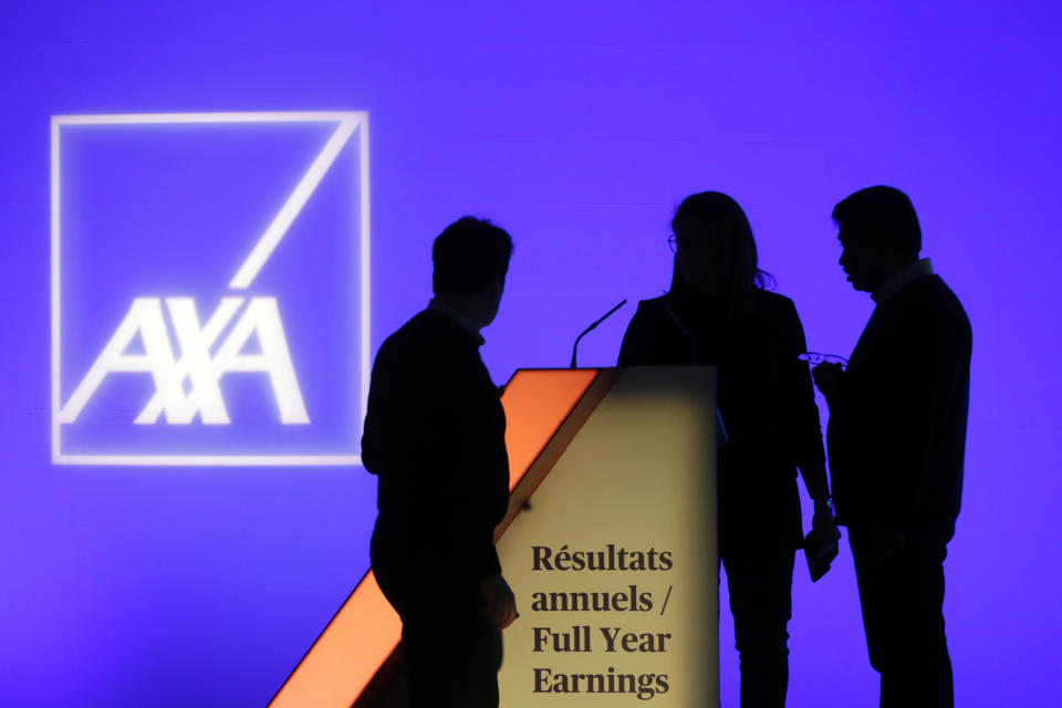 People stand in front of the logo of AXA Group prior to the company's 2018 annual results presentation, in Paris, France, Thursday, Feb. 21, 2019. (AP Photo/Thibault Camus)