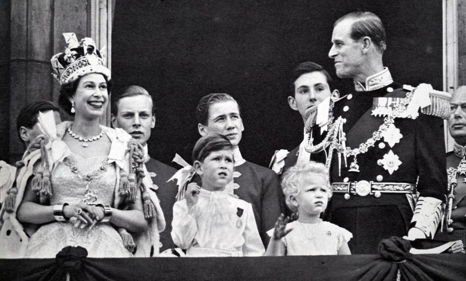 Buckingham Palace balcony. Coronation day 1953. The Queen and the Duke exchange smiles while Prince Charles and Princess Anne are absorbed with the planes roaring overhead. (Photo by: Universal History Archive/Universal Images Group via Getty Images)