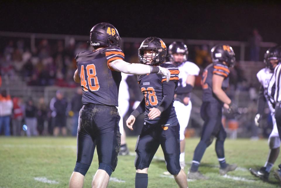 Hudson's Ethan Harris (48) and Nick Kopin (28) celebrate after a tackle during Friday's Division 8 regional final against White Pigeon.