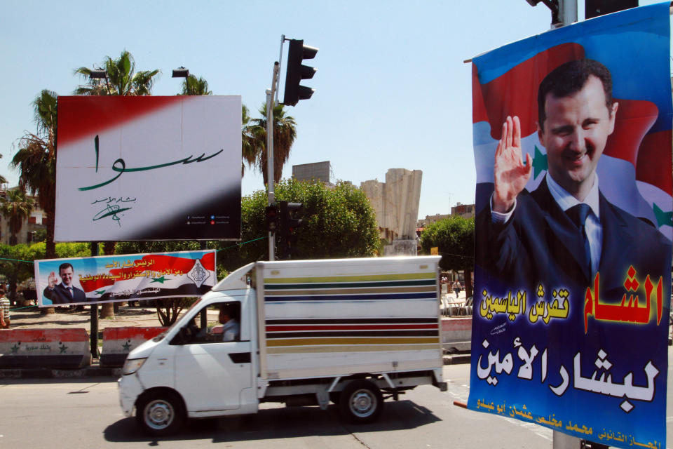 A vehicle drives past campaign posters of the June 3 presidential election in Damascus, Syria, Monday, May 12, 2014. The Arabic on the poster, right, reads, "Damascus spreads flowers for the loyal Bashar." The banner, left, reads, "Together with Bashar Assad." On billboards and in posters taped to car windows, new portraits of President Bashar Assad filled the streets of Damascus on Sunday as Syria officially opened its presidential campaign despite a crippling civil war that has devastated the country and left large chunks of territory outside of government control. Assad faces two other candidates in the race: Maher Hajjar and Hassan al-Nouri, both members of the so-called internal opposition tolerated by the government. (AP Photo)