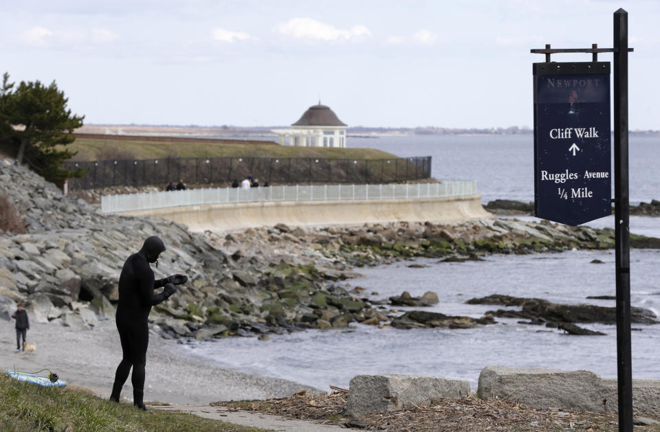 FILE - In this Wednesday, March 27, 2013 file photo Dave Livingston, left, removes his gloves while standing near a portion of the Cliff Walk, in Newport, R.I. Large portions of the Cliff Walk damaged by Superstorm Sandy has yet to be repaired as the summer tourist season approaches. (AP Photo/Steven Senne, File)