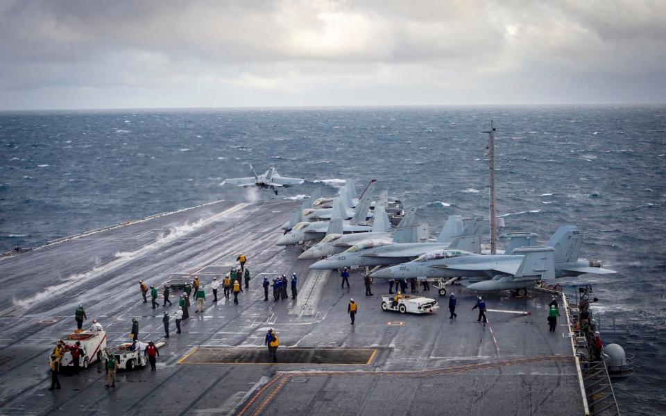 An F/A-18F Super Hornet launching off the runway from an aircraft carrier.