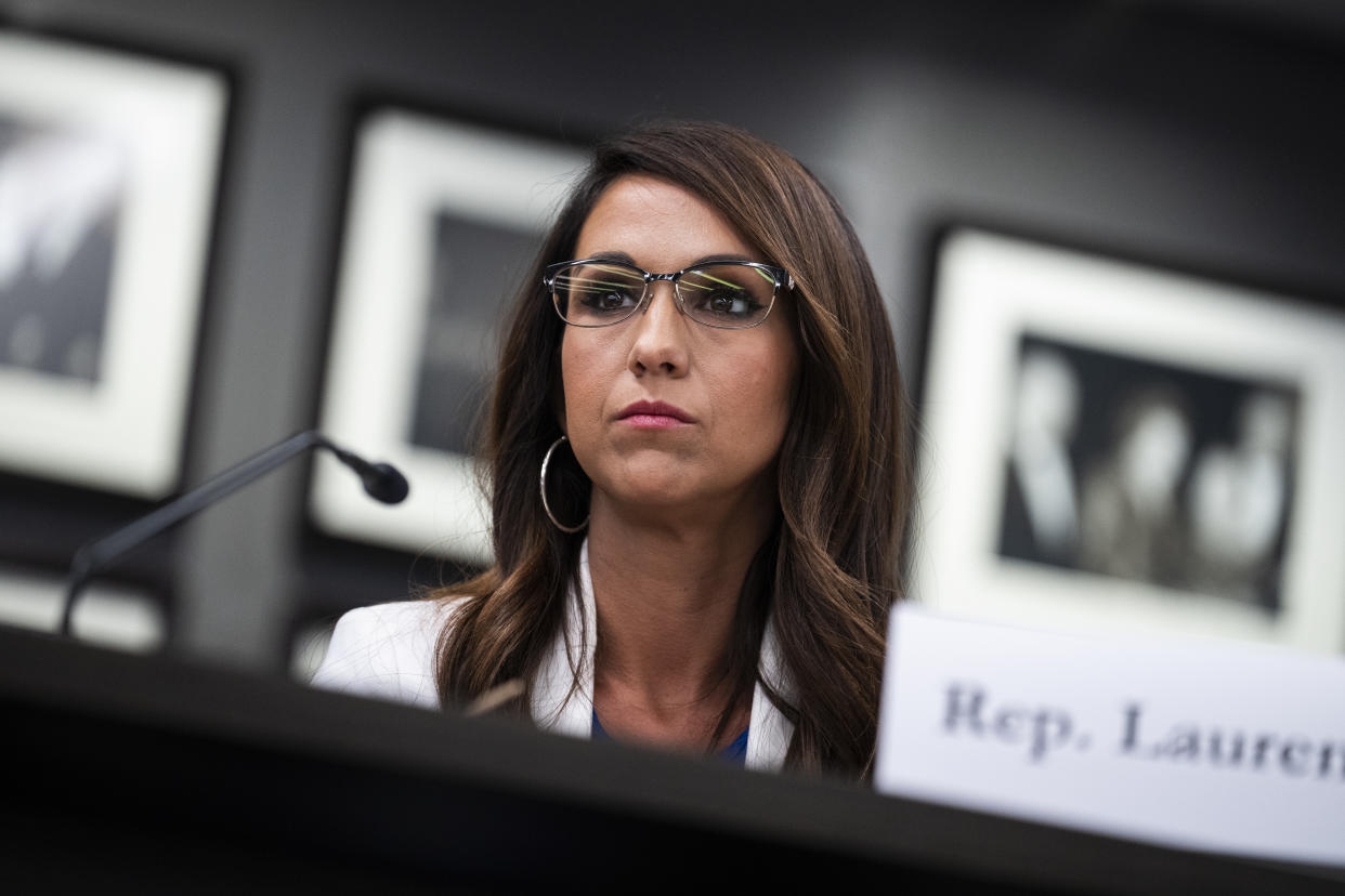 Representative Lauren Boebert sits at a desk during a meeting.