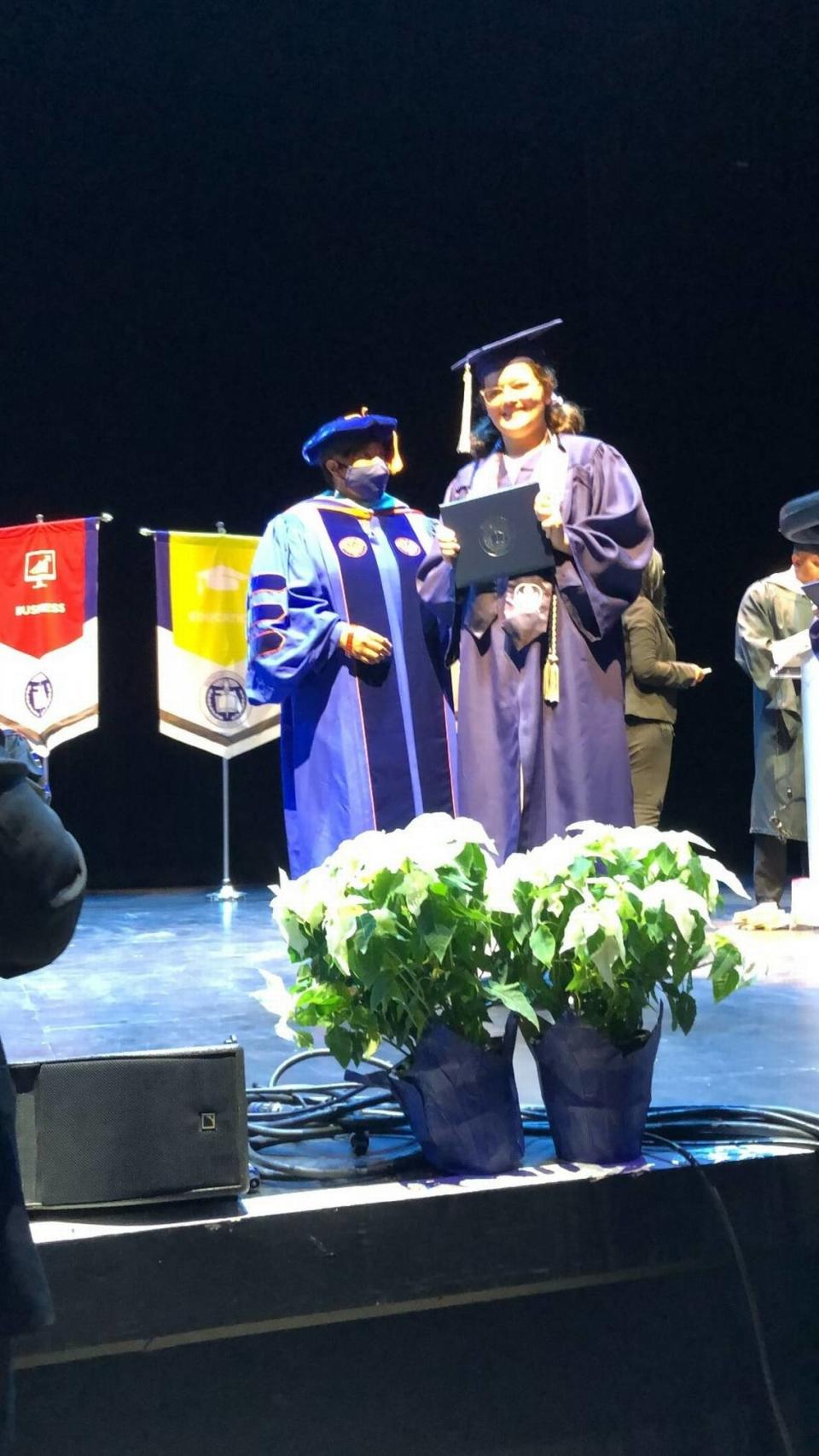 Sawsan Ahmed, right, receives her diploma Wednesday, Dec. 15, 2021, from Broward College. At 12 years old, she is the youngest graduate in the school’s 61-year history. She earned an associate’s degree with a concentration in biology.