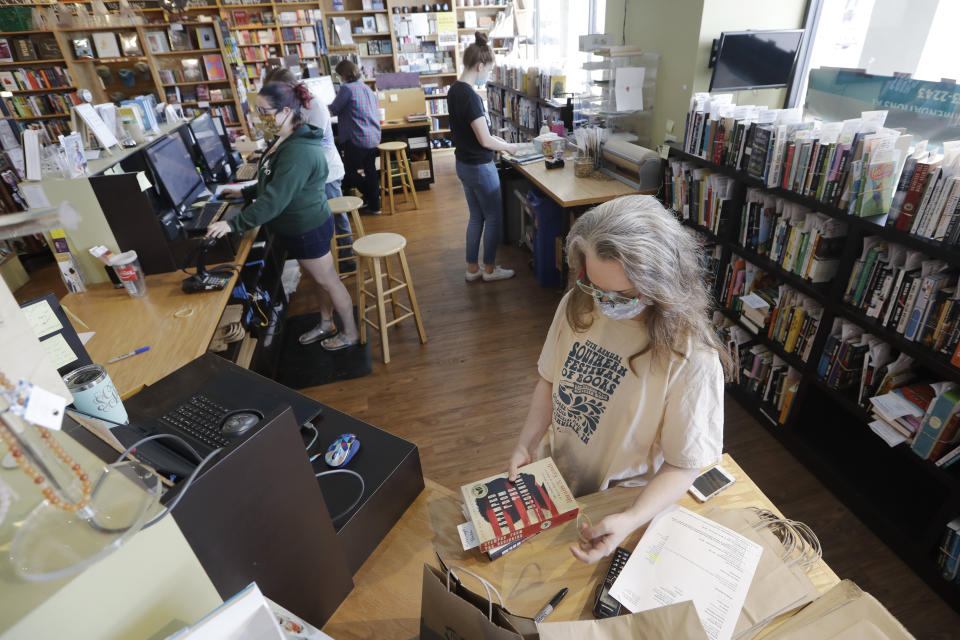 In this Thursday, June 25, 2020, photo, workers fill customers' orders in Parnassus Books in Nashville, Tenn. The independent bookstore, owned by novelist Ann Patchett and Karen Hayes, opened and thrived while others were closing their doors and is once again defying the odds during the coronavirus pandemic. (AP Photo/Mark Humphrey)