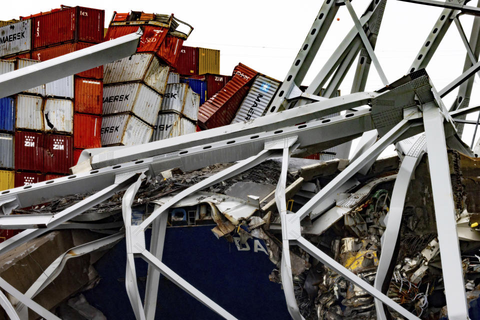 Containers are crushed as wreckage of the Francis Scott Key Bridge rests on the container ship Dali, Wednesday, April 3, 2024, in Baltimore. (AP Photo/Julia Nikhinson)