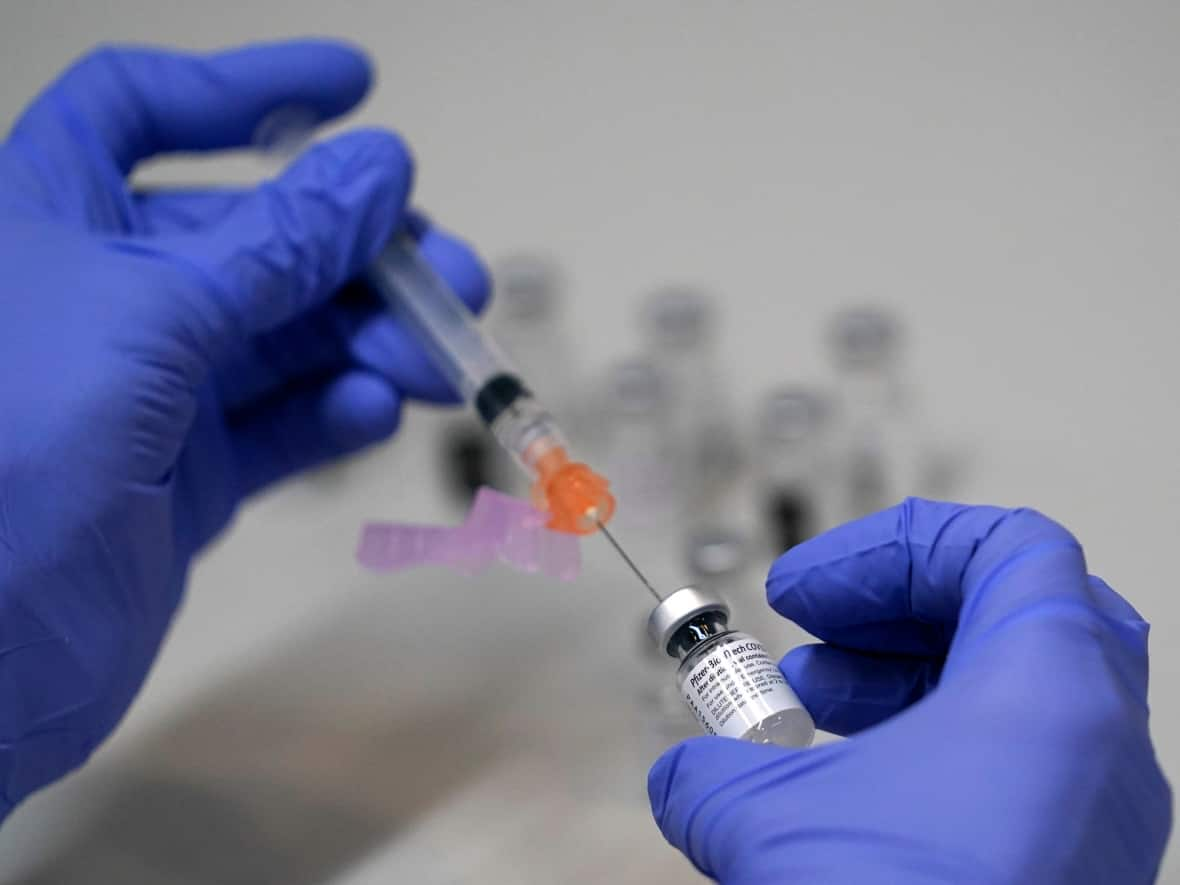 A pharmacy technician loads a syringe with Pfizer's COVID-19 vaccine. Health officials are trying to get Indigenous youth vaccinated, but they remain an elusive demographic to reach. (Robert F. Bukaty/The Associated Press - image credit)