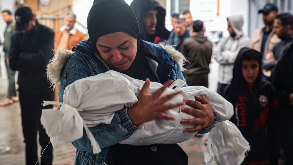 A woman carries the body of a child killed following overnight Israeli strikes on Rafah, May 6, 2024. - AFP/Getty Images