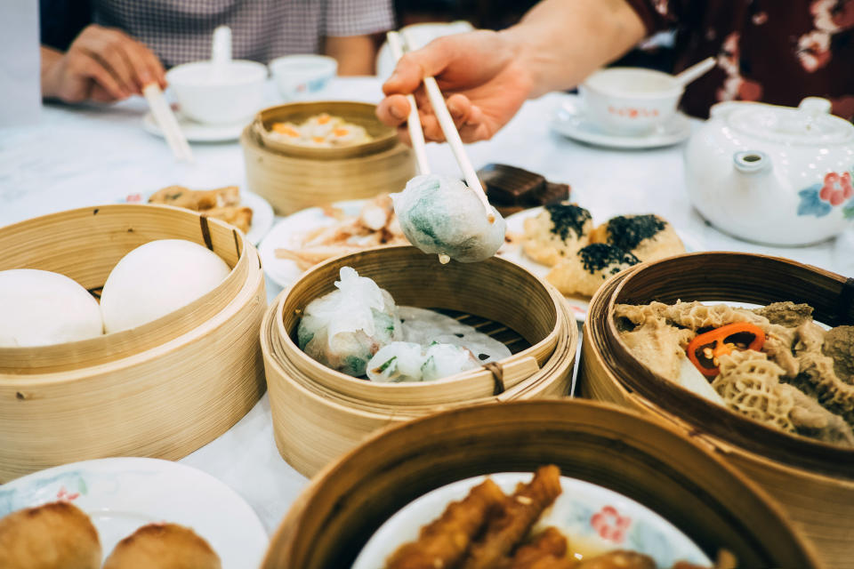 A group of people eating a dim sum meal.