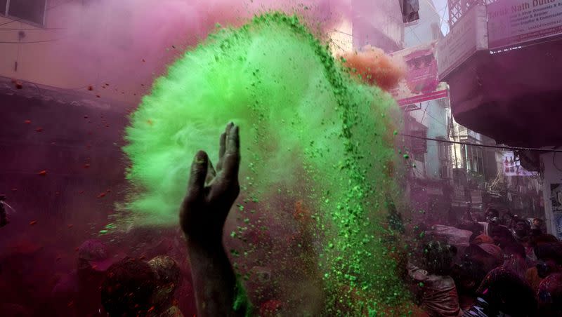 A devotee throws colored powder to others during celebration of the Holi festival on the onset of spring in Kolkata, India, Sunday, March 5, 2023. Millions of Indians on Wednesday celebrated the ‘’Holi” festival, dancing to the beat of drums and smearing each other with green, yellow and red colors and exchanging sweets in homes, parks and streets.