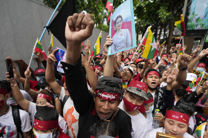Myanmar nationals living in Thailand with a picture of deposed Myanmar leader Aung San Suu Kyi, seen at center, stage a rally outside Myanmar's embassy in Bangkok, Thailand, Tuesday, July 26, 2022. International outrage over Myanmar’s execution of four political prisoners is intensifying with grassroots protests and strong condemnation from world governments. (AP Photo/Sakchai Lalit)