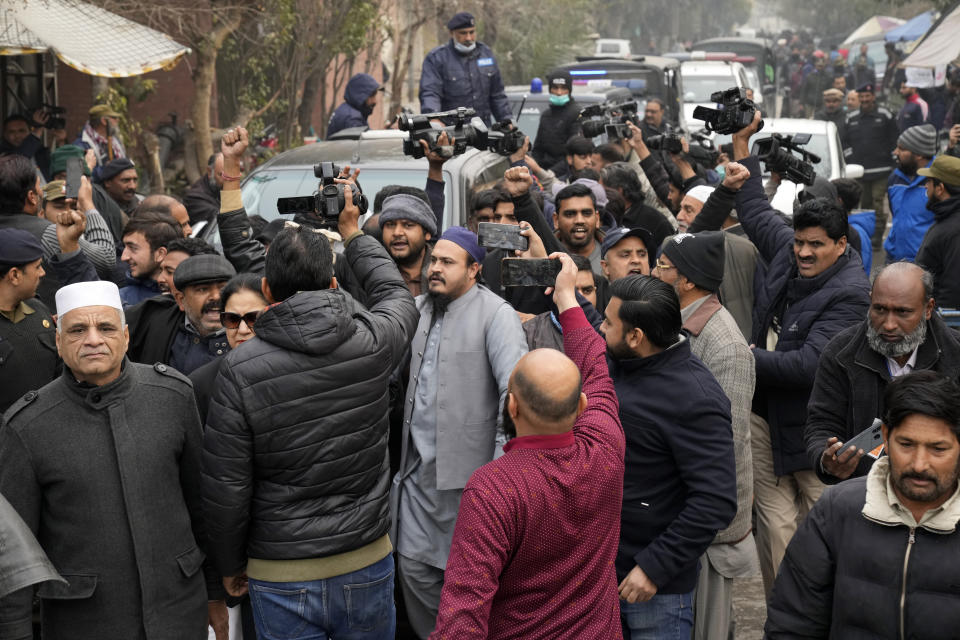 A vehicle carrying Fawad Chaudhry, a senior leader of former Prime Minister Imran Khan's party, is surrounded by media and supporters as it arrives to court in Lahore, Pakistan, Wednesday, Jan. 25, 2023. Police in Pakistan early Wednesday arrested Chaudhry on charges of threatening the chief of the elections overseeing body and other government officials. (AP Photo/K.M. Chaudary)