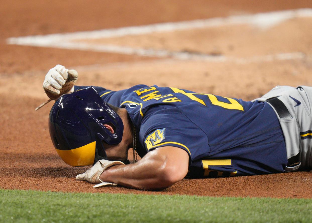 Shortstop Willy Adames writhes in pain Sunday after suffering a sprained left ankle sliding into home plate in the first inning of the Brewers' victory over the Marlins in Miami.