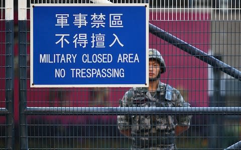 A member of Chinas People's Liberation Army (PLA) stands guard inside Osborn Barracks in Kowloon Tong in Hong Kong on November 16, 2019. - China's President Xi Jinping warned on November 14 that protests in Hong Kong threaten the "one country, two systems" principle governing the semi-autonomous city that has tipped into worsening violence with two dead in a week. - Credit: AFP