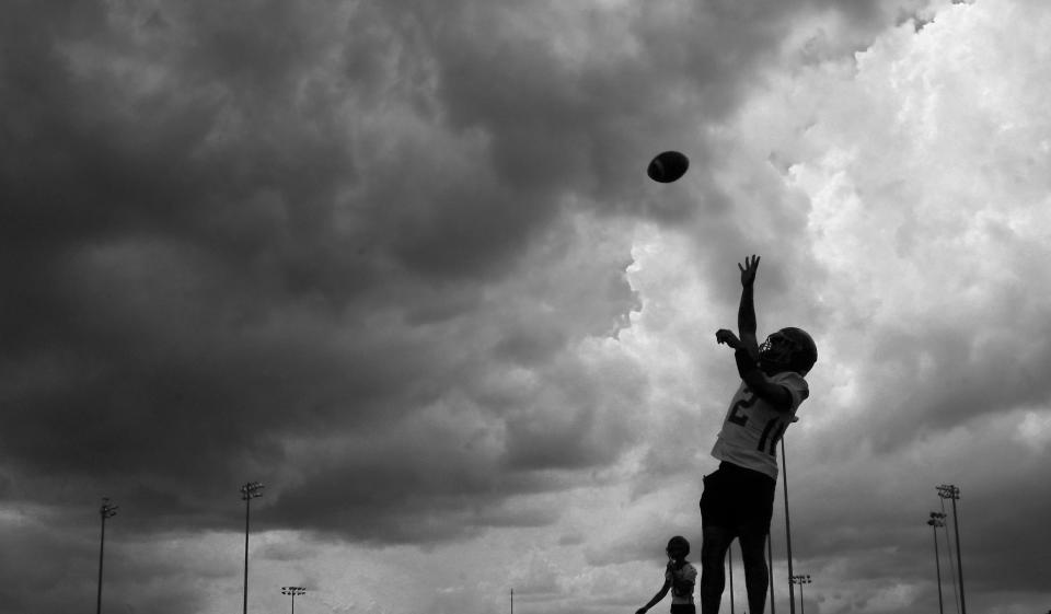 A black and white image of Space Coast Junior/Senior High School Vipers football practice on Tuesday afternoon, as dark rain clouds approached Port St. John. (Syndication: <a class="link " href="https://sports.yahoo.com/ncaab/teams/florida/" data-i13n="sec:content-canvas;subsec:anchor_text;elm:context_link" data-ylk="slk:Florida;sec:content-canvas;subsec:anchor_text;elm:context_link;itc:0">Florida</a> Today)