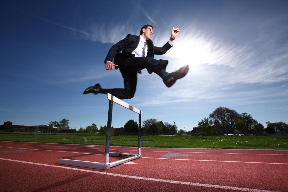 Guy in a suit clearing a hurdle.