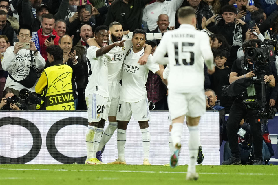 Real Madrid's Karim Benzema, center, celebrates with teammates after scoring the opening goal during the Champions League quarter final first leg soccer match between Real Madrid and Chelsea at Santiago Bernabeu stadium in Madrid, Wednesday, April 12, 2023. (AP Photo/Jose Breton)