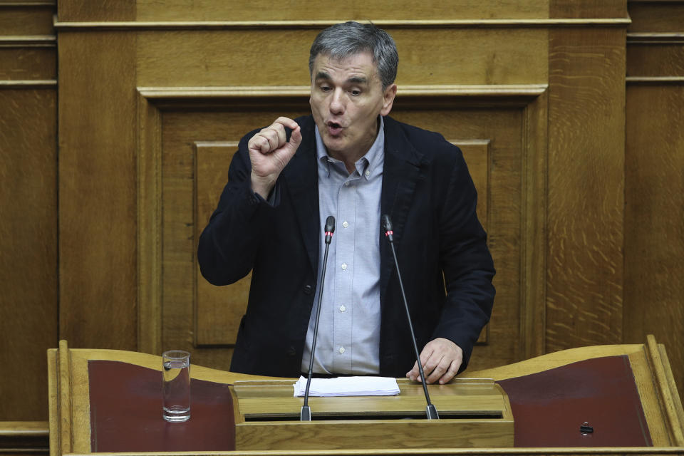 Greek Finance Minister Euclid speaks during a parliament session in Athens on Tuesday, Dec. 18, 2018. Greek lawmakers are debating the heavily-indebted country's draft budget for 2019, the first since Greece exited an eight-year bailout program. (AP Photo/Petros Giannakouris)