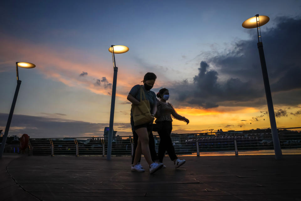 Pedestrians walking along a promenade in Singapore. 