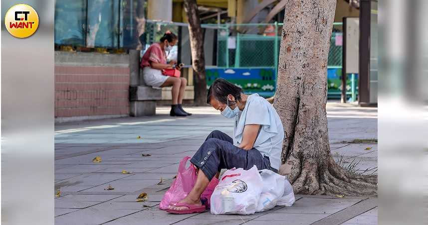 龍山寺如今因疫情而關閉，信眾只能在廟門外膜拜，街友也失去裝水和憩息的重要空間，街頭求生愈發艱辛。（圖／張祐銘攝）