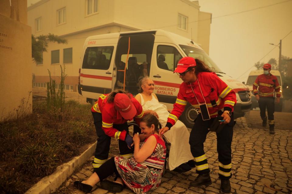 Firefighters evacuate elderly people from a nursing home in the village of Memoria, Portugal (EPA)
