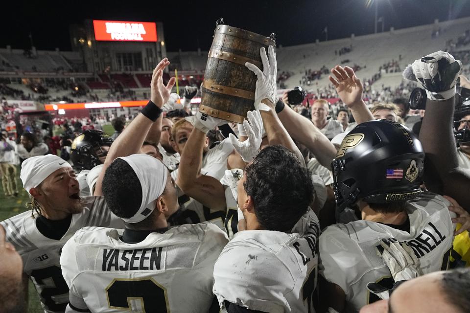 The Purdue football team celebrates with the Old Oaken Bucket after defeating Indiana in an NCAA college football game, Saturday, Nov. 26, 2022, in Bloomington, Ind. (AP Photo/Darron Cummings)