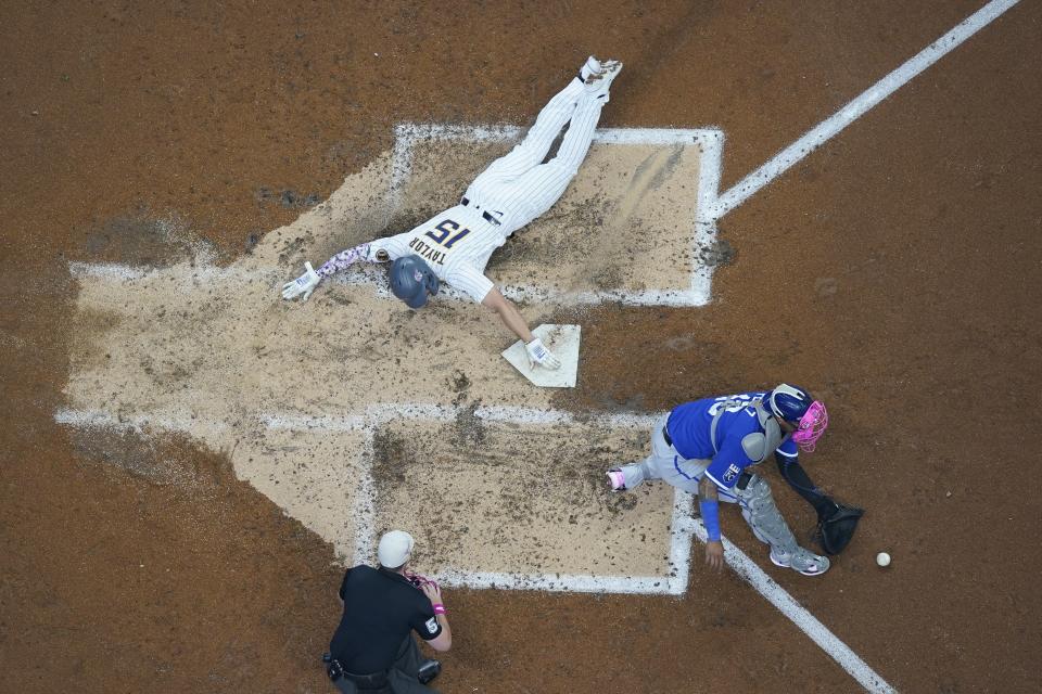 Milwaukee Brewers' Tyrone Taylor scores past Kansas City Royals catcher Salvador Perez during the third inning of a baseball game Sunday, May 14, 2023, in Milwaukee. Taylor scored on a hit by Christian Yelich. (AP Photo/Morry Gash)