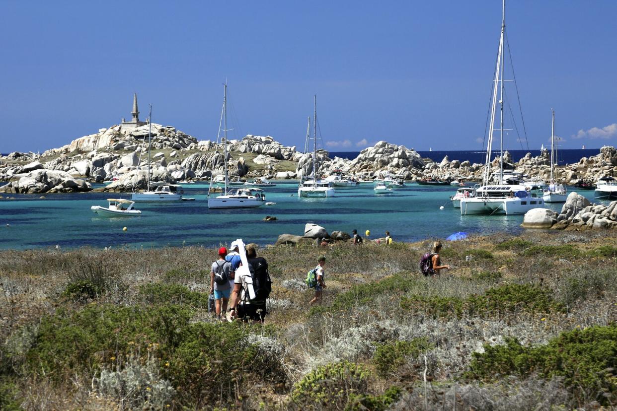 Tourists walk to a white sand beach at the Lavezzi islands, close from Bonifacio on the French Mediterranean island of Corsica, on July 10, 2022.