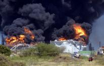 El incendio provocado por una explosión en la mayor refinería de Venezuela seguía activo el domingo, más de 36 horas después del fatal accidente que dejó 41 muertos así como varios militares desaparecidos en la zona, visitada por el presidente Hugo Chávez. (AFP | leo ramirez)