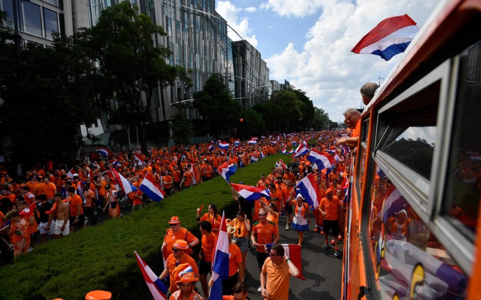 Netherlands fans with flags in a fanzone before the match - Reuters