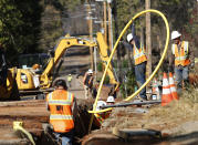 FILE - In this Oct. 18, 2019, file photo, Pacific Gas and Electric Company workmen bury utility lines in Paradise, Calif. California regulators are voting Wednesday, Nov. 13, on whether to open an investigation into pre-emptive power outages that blacked out large parts of the state for much of October as strong winds sparked fears of wildfires. PG&E officials insisted on the shut-offs to prevent wildfires but a parade of public officials complained the company botched its communications. (AP Photo/Rich Pedroncelli, File)