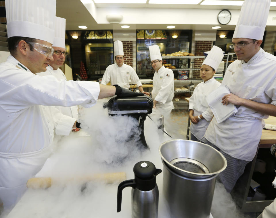 In this image taken on Friday, Sept. 14, 2012, Chef Francisco Migoya, left, demonstrates how to make strawberry sorbet by applying liquid nitrogen to a puree mixture at the Culinary Institute of America in Hyde Park, N.Y. This esteemed cooking school north of New York City is dramatically pumping up science instruction, saying that tomorrow's chefs will need more technical know-how in the age of molecular gastronomy and sous-vide. (AP Photo/Mike Groll)