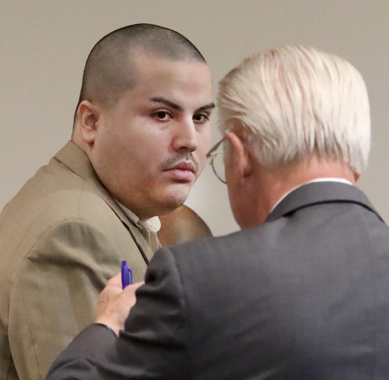 Emanuelle Vazquez speaks with his defense attorney, Assistant Public Defender John Selden, Tuesday, Feb. 28, 2023, during his first-degree felony murder trial in the death of his infant son.