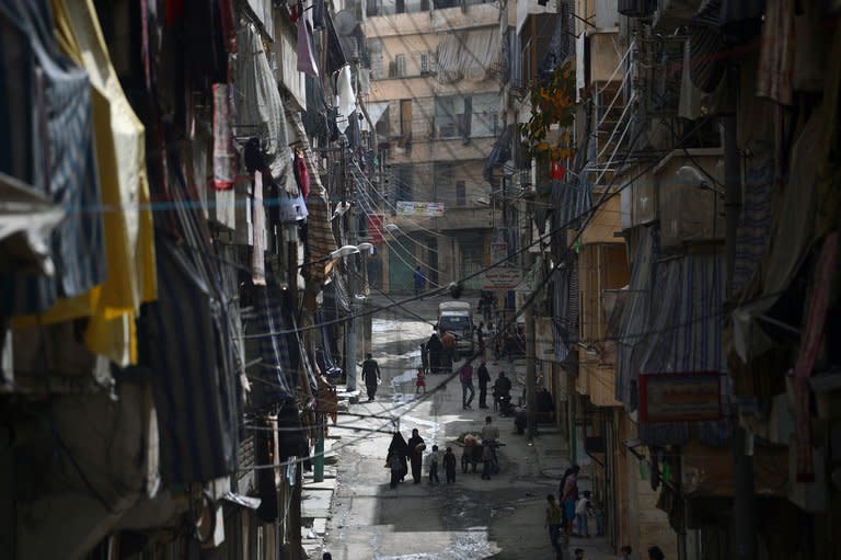 Syrians walk in a street in the Saladin district of the northern Syrian city of Aleppo on April 8, 2013