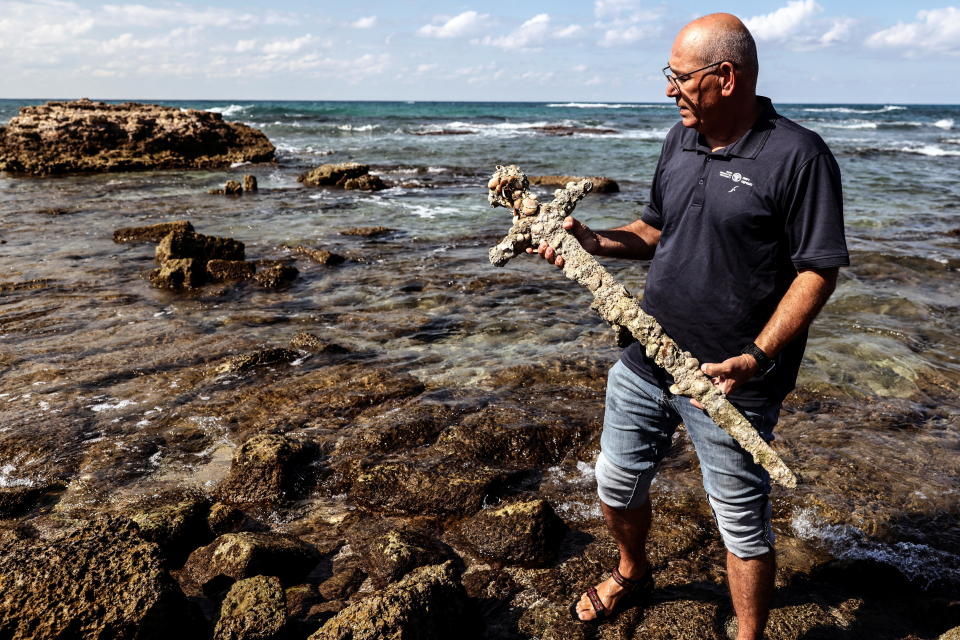 Yaakov Sharvit of the IAA holds a sword believed to have belonged to a Crusader who sailed to the Holy Land almost a millennium ago after it was recovered from the Mediterranean seabed by an amateur diver. / Credit: RONEN ZVULUN / REUTERS