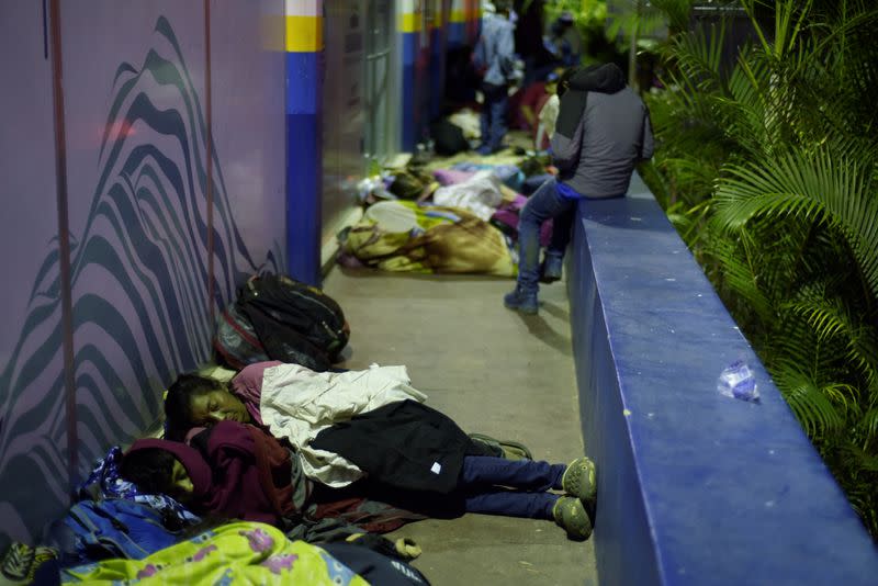 People, part of a caravan of migrants heading toward the United States, rest at the border between Honduras and Guatemala in Agua Caliente