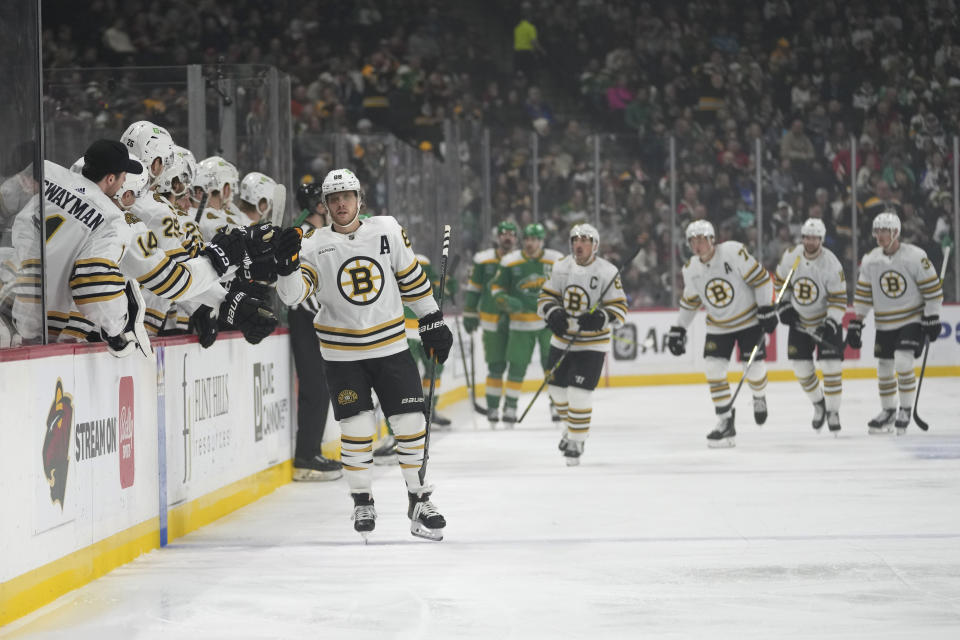 Boston Bruins right wing David Pastrnak (88) celebrates with teammates after scoring during the first period of an NHL hockey game against the Minnesota Wild, Saturday, Dec. 23, 2023, in St. Paul, Minn. (AP Photo/Abbie Parr)