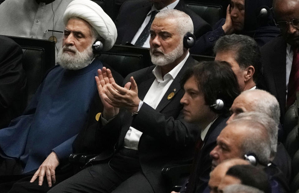 Hamas chief Ismail Haniyeh claps as newly-elected Iranian President Masoud Pezeshkian speaks while deputy leader of the Lebanese militant group Hezbollah, Sheikh Naim Kassem, left, sits during the swearing-in ceremony of Pezeshkian at the Iranian parliament, in Tehran, Iran, Tuesday, July 30, 2024. (AP Photo/Vahid Salemi)