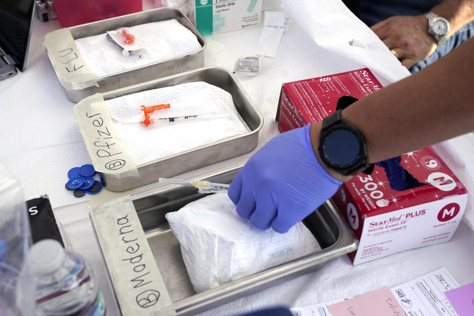 FILE - Syringes with vaccines are prepared at the L.A. Care and Blue Shield of California Promise Health Plans' Community Resource Center where they were offering members and the public free flu and COVID-19 vaccines Oct. 28, 2022, in Lynwood, Calif. Updated COVID-19 vaccines are expected in the latter half of 2023 — just in time to pair them with flu shots. (AP Photo/Mark J. Terrill, File)