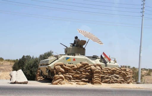 An Egyptian army vehicle keeps its position close to the Rafah border crossing with the Hamas-run Gaza Strip. Egypt's army vowed Monday to "avenge" the killing of 16 troops by gunmen near the Israeli border and President Mohamed Morsi won US backing as he ordered his security forces to take full control of the Sinai