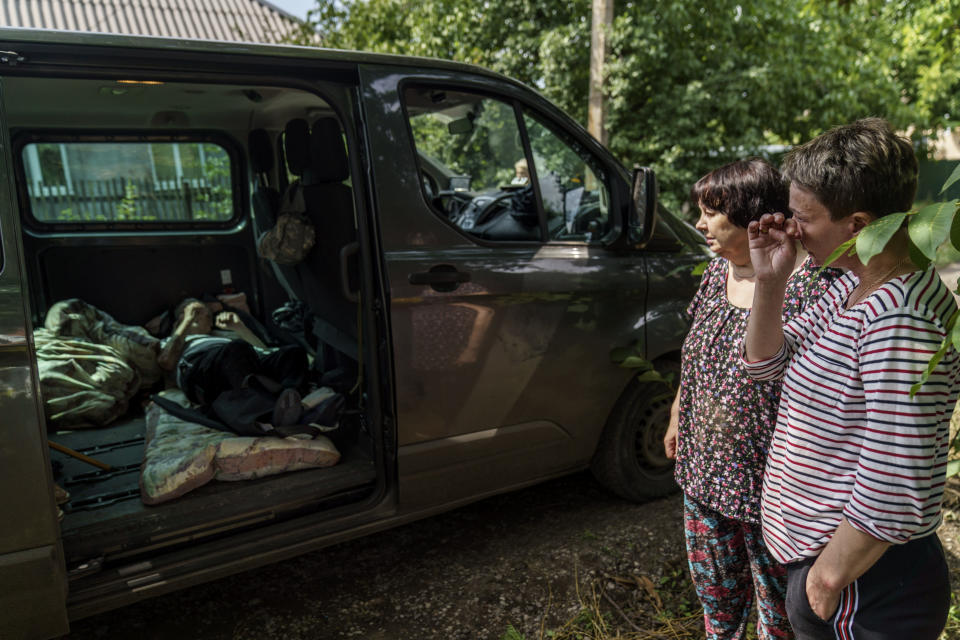 Marina Havrysh, right, wipes a tear away while saying goodbye to her elderly parents as they're evacuated to a safer part of the country in the west from their home in Kramatorsk, Donetsk region, eastern Ukraine, Tuesday, Aug. 2, 2022. "I understand that this will be the last time I ever see them," she said. "You see their age, I can't give them the proper care." (AP Photo/David Goldman)