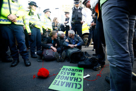 Police officers stand around protesters sitting in the road outside the Houses of Parliament during a demonstration against fracking, in London, Britain, October 31, 2018. REUTERS/Henry Nicholls