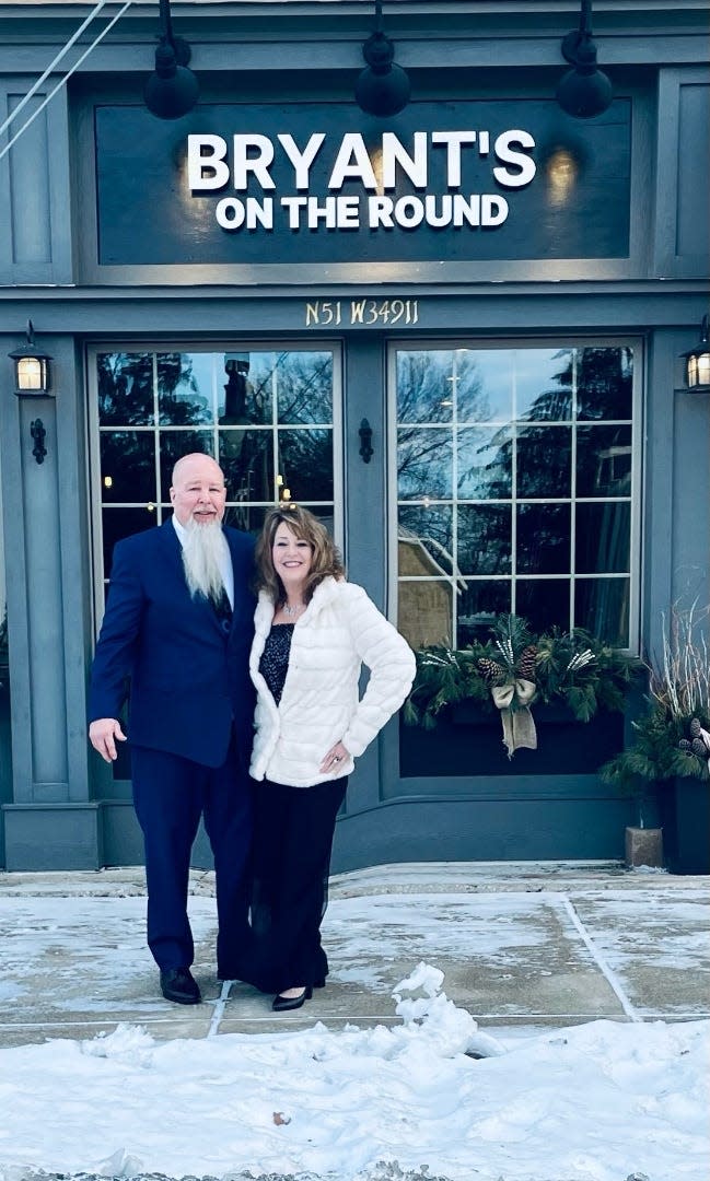 Bryant Johnson and his fiancé, Kimberly Stark, pose in front of Bryant's on the Round in Okauchee.